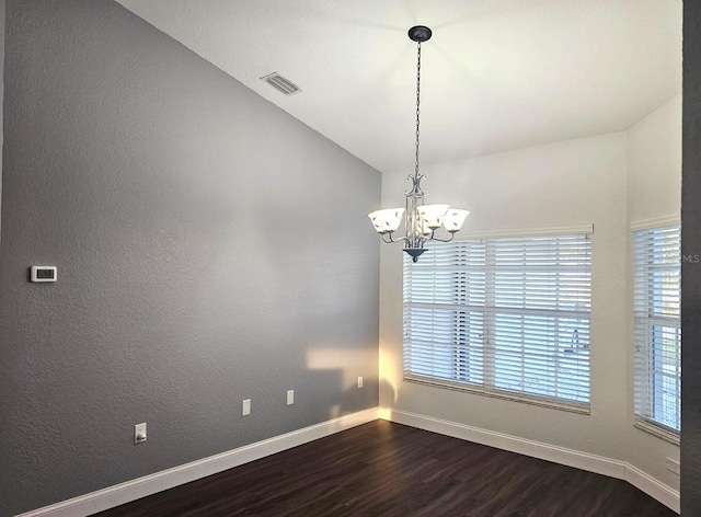 spare room featuring an inviting chandelier, hardwood / wood-style flooring, and lofted ceiling