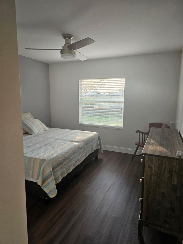 bedroom with dark hardwood / wood-style flooring and ceiling fan