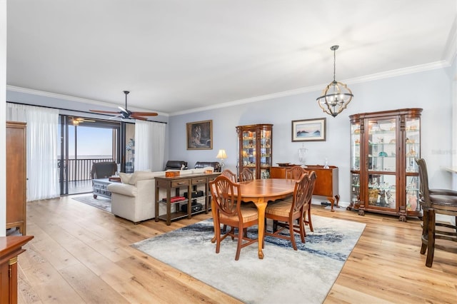 dining space featuring ornamental molding, ceiling fan with notable chandelier, and light hardwood / wood-style flooring