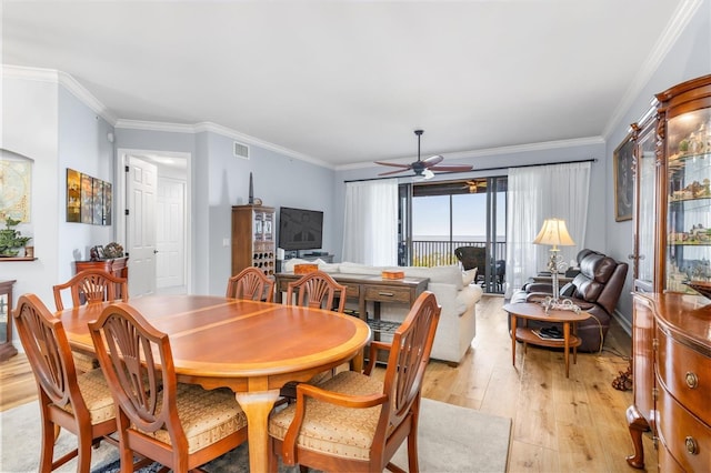 dining room featuring light hardwood / wood-style flooring, ornamental molding, and ceiling fan