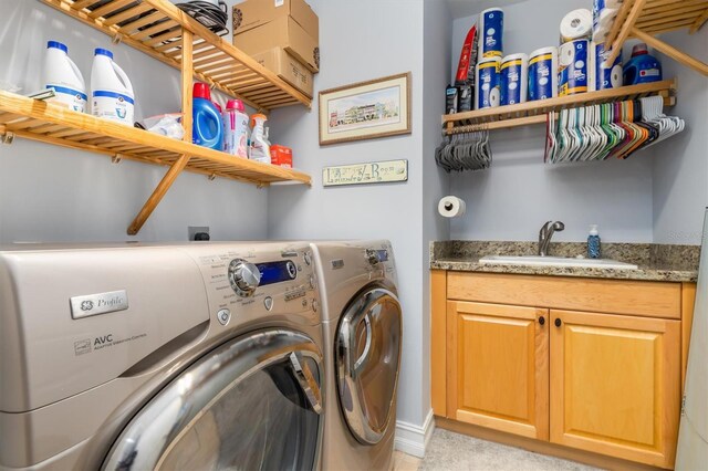 clothes washing area featuring cabinets, separate washer and dryer, and sink