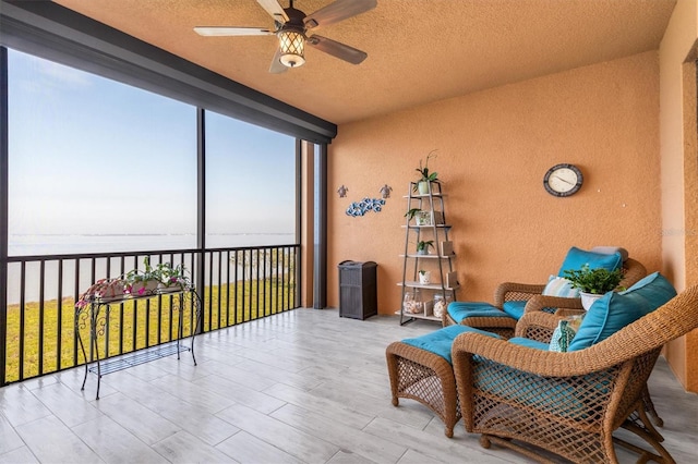 sunroom / solarium with a water view and ceiling fan