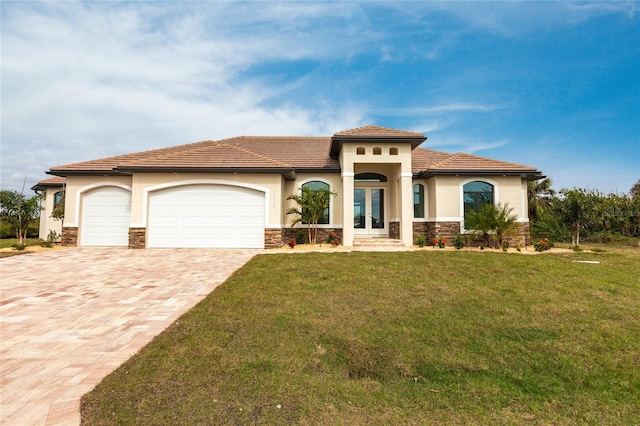 mediterranean / spanish house with a garage, a front yard, and french doors