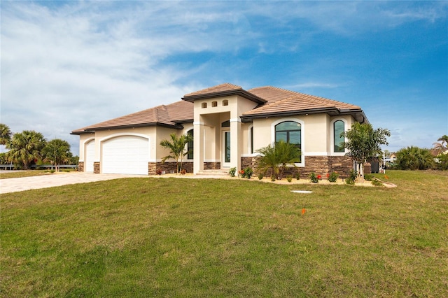 mediterranean / spanish-style home featuring a garage and a front lawn