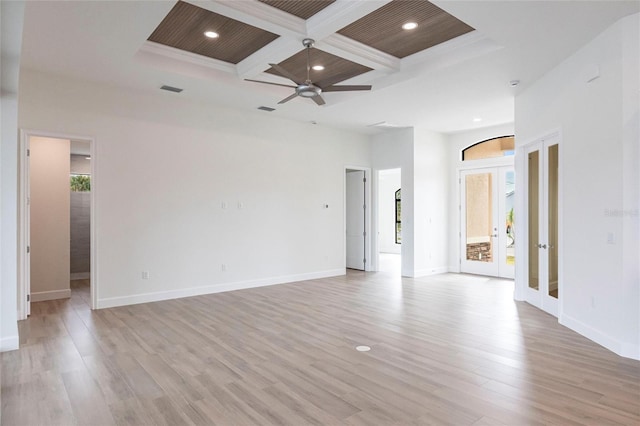 spare room featuring french doors, coffered ceiling, light hardwood / wood-style flooring, ceiling fan, and beam ceiling