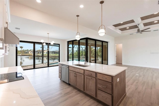 kitchen featuring a water view, dishwasher, sink, and hanging light fixtures