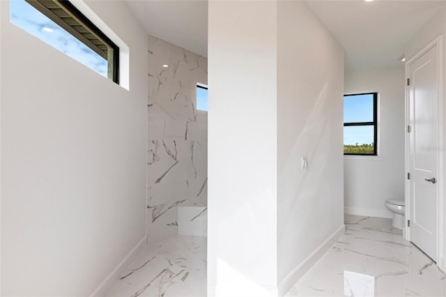 bathroom featuring toilet and a tile shower