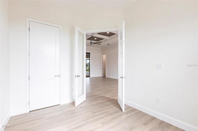 hall with coffered ceiling, beam ceiling, and light hardwood / wood-style flooring