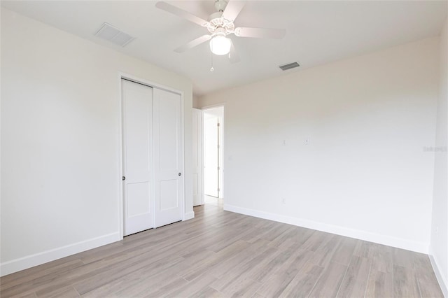 unfurnished bedroom with light hardwood / wood-style floors, a closet, and ceiling fan