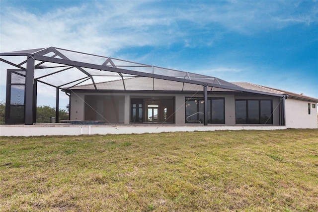 back of property featuring glass enclosure and a lawn