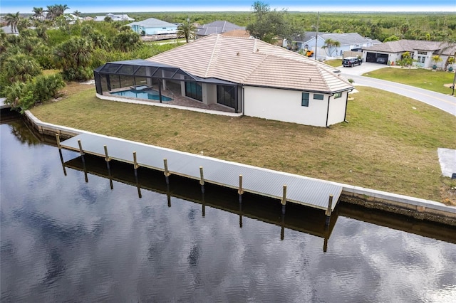 exterior space with a water view, a lanai, and a lawn