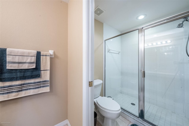 bathroom featuring a shower with shower door and toilet