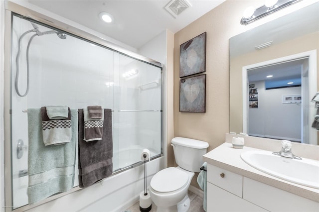 full bathroom featuring toilet, vanity, and shower / bath combination with glass door