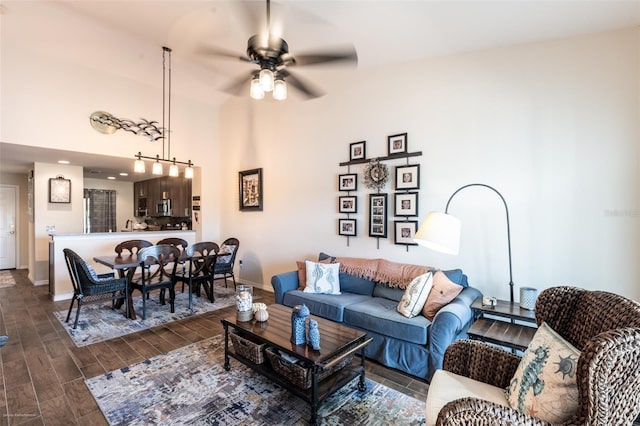 living room featuring dark wood-type flooring and ceiling fan