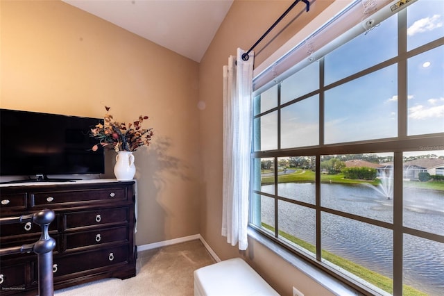 carpeted office space featuring a water view, lofted ceiling, and plenty of natural light