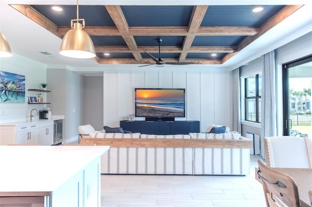 living room featuring coffered ceiling, sink, and beam ceiling