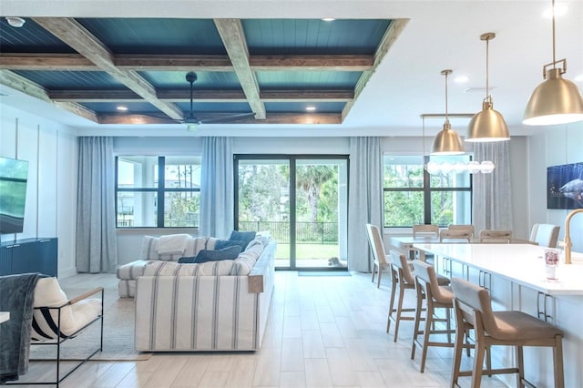 interior space with coffered ceiling, beamed ceiling, a chandelier, and plenty of natural light