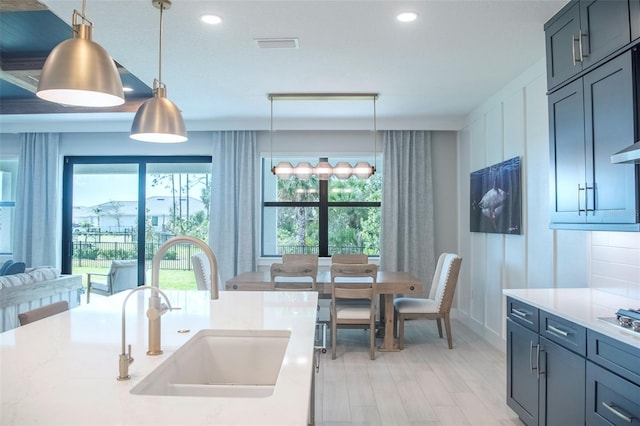 kitchen featuring sink, light wood-type flooring, and pendant lighting