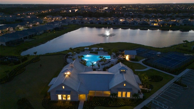 aerial view at dusk featuring a water view