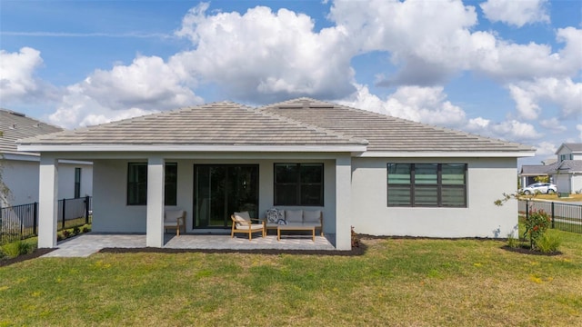 back of house with an outdoor living space, a patio area, and a lawn