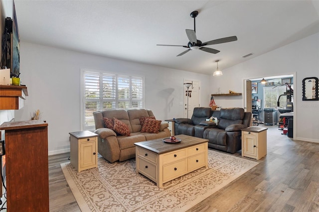 living room with lofted ceiling, ceiling fan, light hardwood / wood-style flooring, and a healthy amount of sunlight