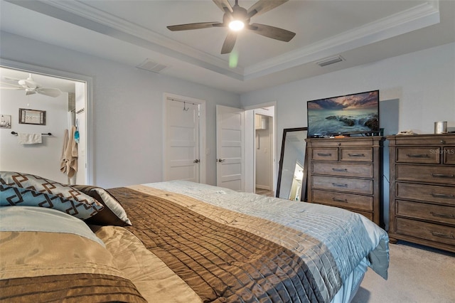 bedroom featuring crown molding, light colored carpet, a tray ceiling, and ceiling fan