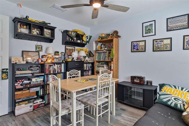 dining space featuring wood-type flooring and ceiling fan