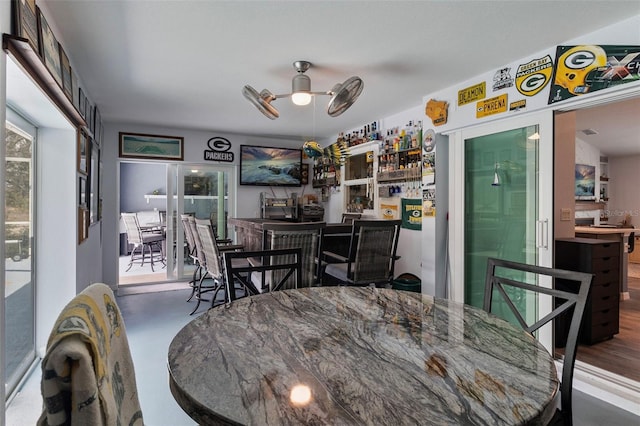 dining room with ceiling fan and bar