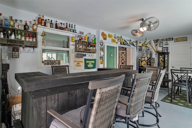 bar with concrete flooring and a textured ceiling