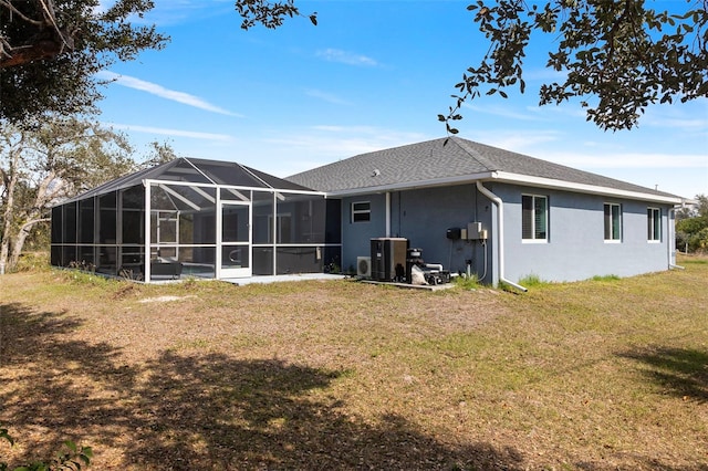 rear view of property featuring glass enclosure and a lawn