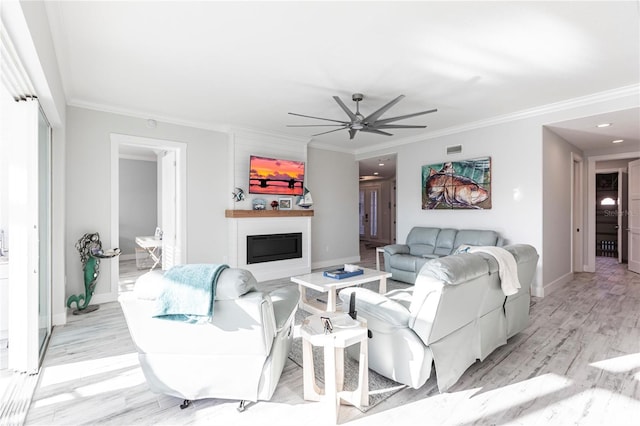 living room featuring ornamental molding, light hardwood / wood-style floors, and ceiling fan