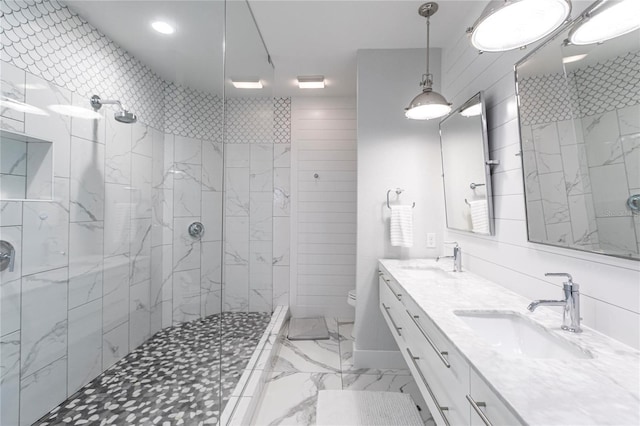 bathroom featuring tiled shower, vanity, and toilet