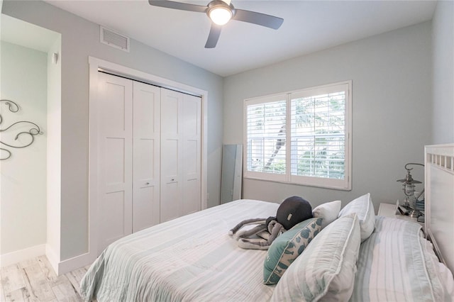 bedroom featuring ceiling fan, light hardwood / wood-style floors, and a closet