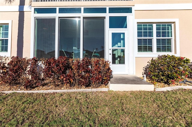 doorway to property featuring a lawn