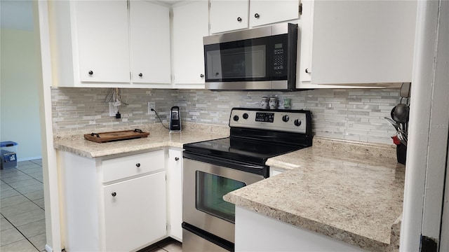 kitchen featuring white cabinetry, appliances with stainless steel finishes, light tile patterned flooring, and tasteful backsplash