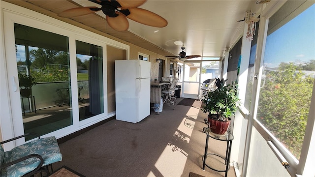 unfurnished sunroom with ceiling fan