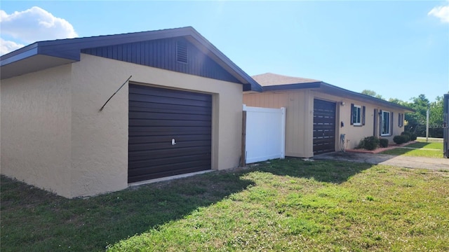 view of property exterior featuring a garage and a lawn