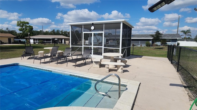 view of swimming pool with a patio area, a sunroom, and a lawn