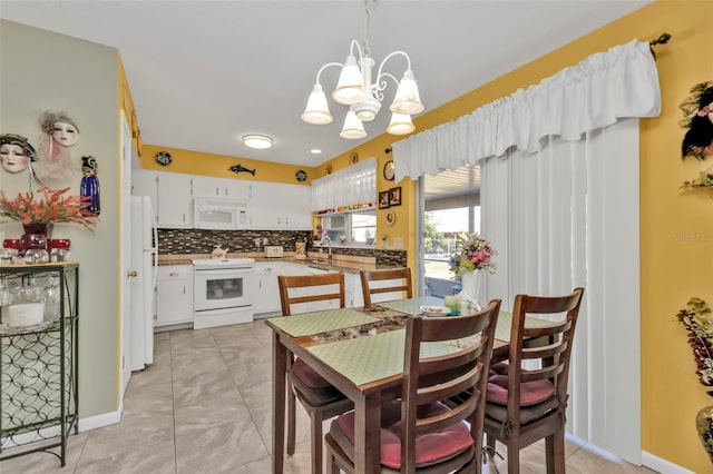 kitchen featuring pendant lighting, white appliances, white cabinets, decorative backsplash, and a chandelier