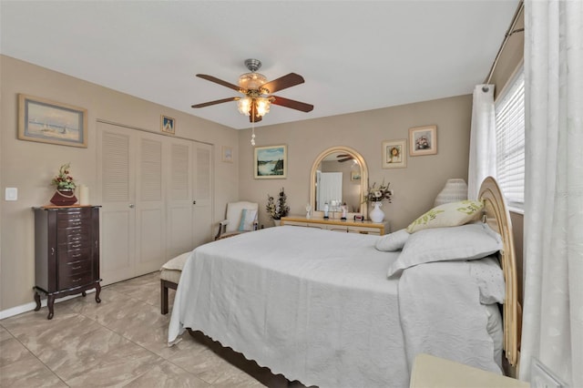 bedroom featuring light tile patterned flooring, ceiling fan, and a closet