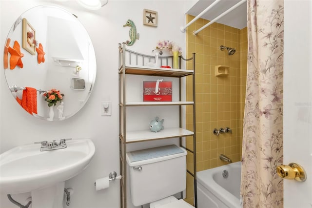 full bathroom featuring sink, shower / tub combo with curtain, and toilet