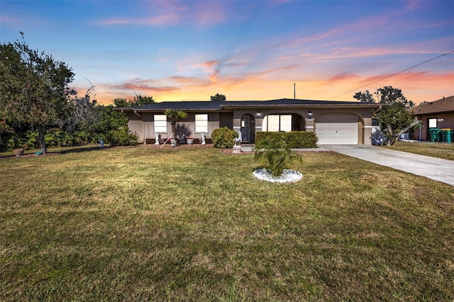 ranch-style house featuring a garage and a yard