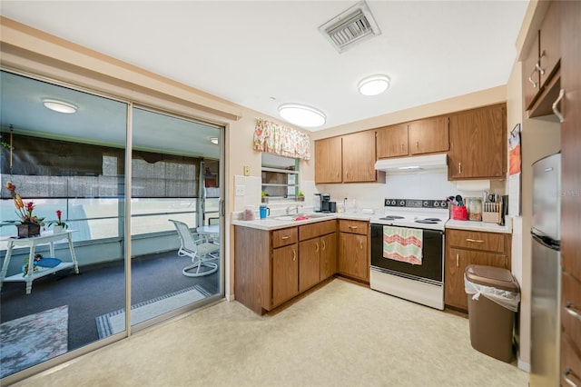 kitchen featuring sink, stainless steel fridge, and white electric range oven