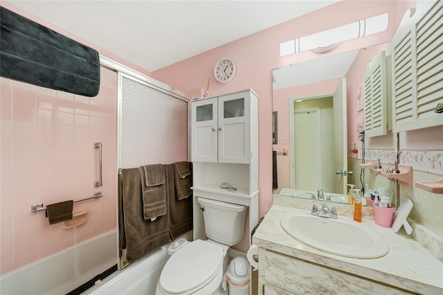 full bathroom featuring vanity, tiled shower / bath, a textured ceiling, and toilet