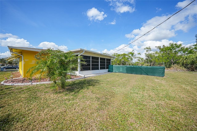 rear view of property with a yard and a sunroom