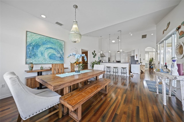 dining area with a towering ceiling and dark hardwood / wood-style flooring