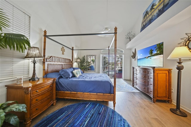 bedroom featuring a high ceiling and light wood-type flooring