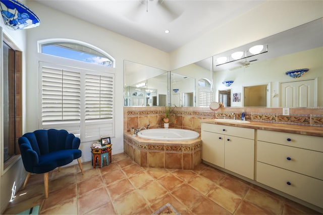 bathroom featuring ceiling fan, vanity, tile patterned flooring, and tiled tub