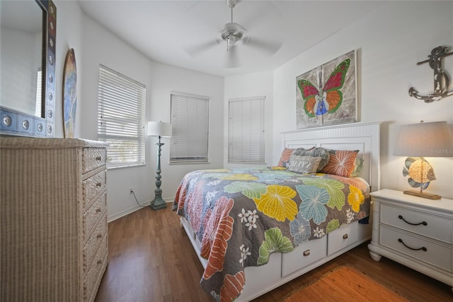 bedroom with dark hardwood / wood-style flooring and ceiling fan