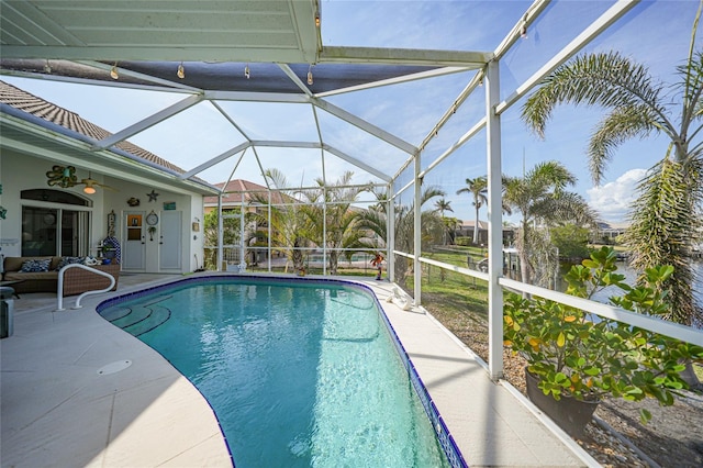 view of pool featuring a lanai, a patio area, and ceiling fan